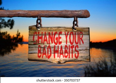 Change your bad habits motivational phrase sign on old wood with blurred background
