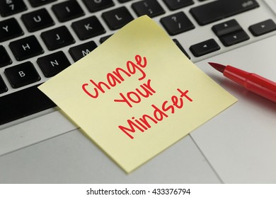 Change Your Mindset sticky note pasted on the keyboard