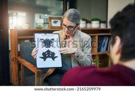 Change your perception, transform your life. Shot of a mature psychologist conducting an inkblot test with her patient during a therapeutic session.