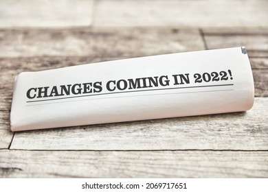 Changes coming in 2022 is written on the front page of a folded newspaper on a wooden table