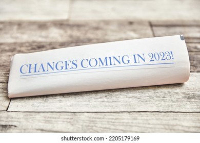 Changes coming in 2023 is written on the front page of a folded newspaper on a wooden table - Shutterstock ID 2205179169