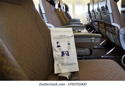 Changi Airport, Singapore - 31st March 2021: Empty Plane Cabin With Covid - 19 Prevention Care Kit On The Seat Containing Hand Gel, Face Mask And Antibacterial Wipes