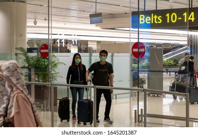 Changi Airport, Singapore / Singapore - February 09 2020: People Wearing Masks And Walking In The Airport Due To Wuhan CoronaVirus  COVID 19