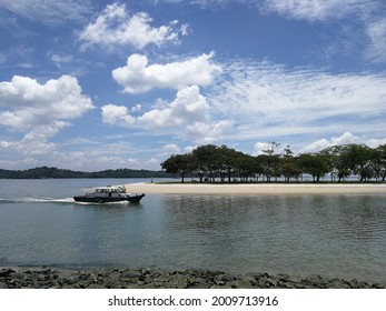 Changi beach park in a clear sunny day, blue sky, sea and a boat