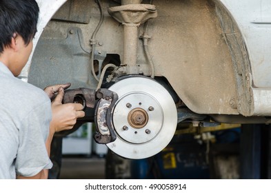 Changing brake disc with technician - Shutterstock ID 490058914