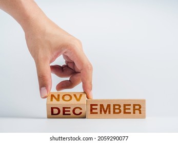 Changing to the last month of the year. The hand is flipping wooden cube blocks for change words, months from November to December on the desk on white background, clean, modern, and minimal style. - Shutterstock ID 2059290077