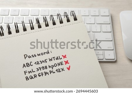 Changing password. Notebook with correct and incorrect passwords and keyboard on table, closeup