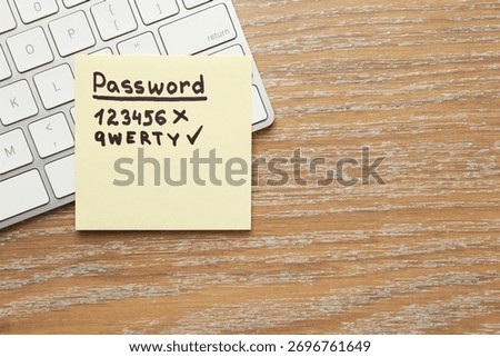 Changing password. Sticky note with weak and strong passcodes near computer keyboard on wooden table, top view. Space for text