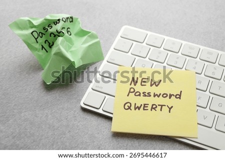 Changing password. Sticky notes with old and new passcodes near computer keyboard on grey table, closeup
