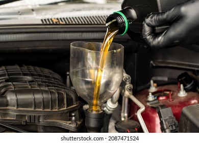 Changing Replacement Car Oil With Plastic Bottle. DIY Change Engine Motor Oil. At Home Vehicle Maintenance. Garage Mechanic Concept