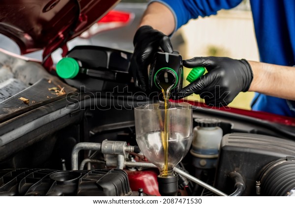 Changing replacement car oil with plastic bottle.\
DIY change engine motor oil. At home vehicle maintenance. Garage\
mechanic concept