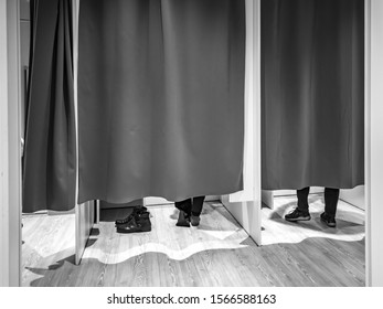 Changing Room With Closed Curtains And Feet Of Two Customers