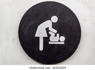 Changing Table And Bathroom Signs On The Wall