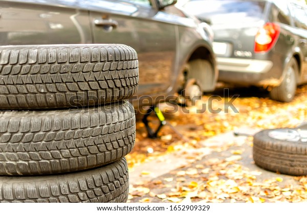 changing the tires of a car from  summer tires to\
winter tires in autumn