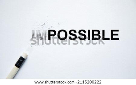 Changing the word impossible to possible with a pencil eraser.