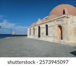 Chania Mosque, The Küçük Hasan Pasha Mosque or Yalı Mosque, with Chania lighthouse in the backround, in Crete, Greece