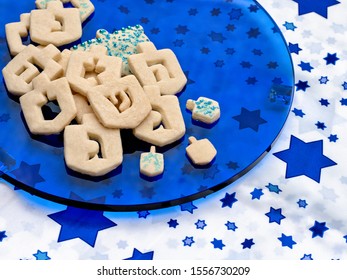 Chanukah Dreidel Cookies On A Blue Glass Plate  With Copy Space