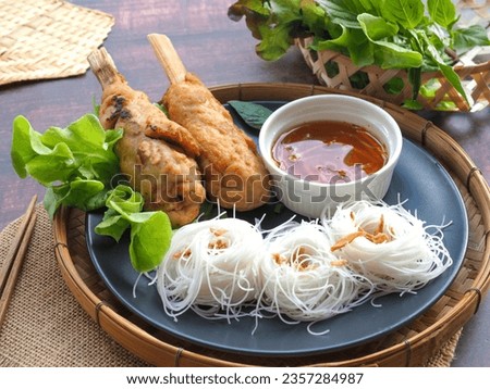 Chao Tom - Vietnamese food of Fried Shrimp sugar cane served with vermicelli, sweet sauce and vegetables at close up view