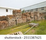 A chaotic junkyard scrapyard filled with broken bricks stacked on wooden pallets. Industrial debris, construction waste, and weathered materials create a gritty, urban decay scene.