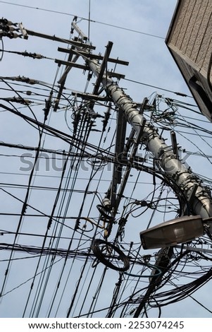 Chaotic web of electric wires in Fukuoka city, Japan. Asian mess of electric cables 