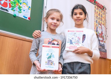 Chapaevsk, Samara region, Russia - December 24, 2020: Two elementary school girls are standing in the classroom at the blackboard with books