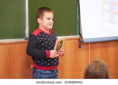Chapaevsk, Samara region, Russia - December 24, 2020: A primary school schoolboy with a book at the blackboard tells a lesson