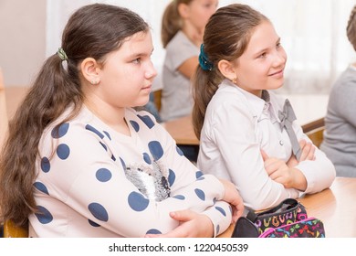 CHAPAEVSK, SAMARA REGION, RUSSIA - OCTOBER 24, 2018: Two girls in the classroom at the Desk listening to the teacher
