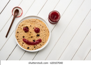 Chapati Roll with Tomato Ketchup Or Fruit Jam/Jelly with smily face, indian kid's favourite food menu for school tiffin box, selective focus - Powered by Shutterstock