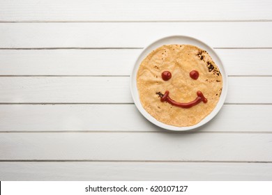 Chapati Roll with Tomato Ketchup Or Fruit Jam/Jelly with smily face, indian kid's favourite food menu for school tiffin box, selective focus - Powered by Shutterstock