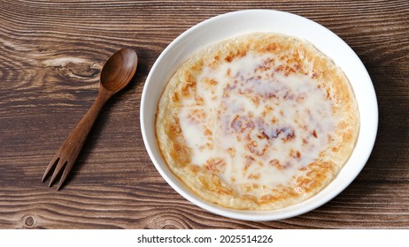 Chapati a thin pancake known as roti topping with sweet condense milk, Indian traditional street food.