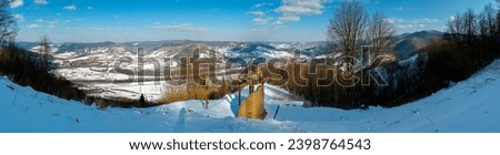 Chapel at the height of the mountain in winter with a wonderful panorama of peaks and forest under a clear sky. Photo for banner.