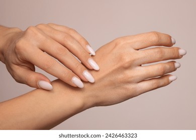 Chapped female hands close-up with dry skin and cracks on the fingers. Isolated on a light background. Horny white cuticle at the base of the nails. Sensitive skin care concept - Powered by Shutterstock