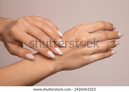 Chapped female hands close-up with dry skin and cracks on the fingers. Isolated on a light background. Horny white cuticle at the base of the nails. Sensitive skin care concept