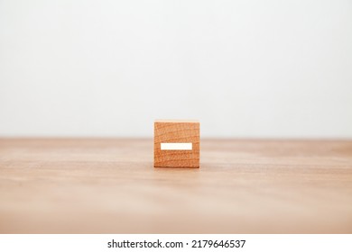 -Character. minus. Written on a wooden block. White letters. Wooden table background.