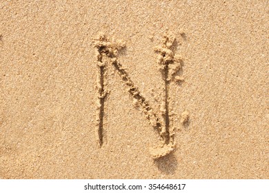 Character N Handwritten On Sand.