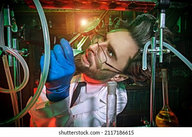 Character of a science fiction novel. A crazy scientist conducts strange experiments in his laboratory and looks through magnifying glass at how his new invention works.