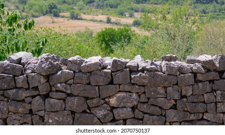 Characteristic stone dry wall in Crotia, green nature background