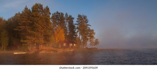 Characteristic Swedish Wood House At The Lake With Morning Fog.