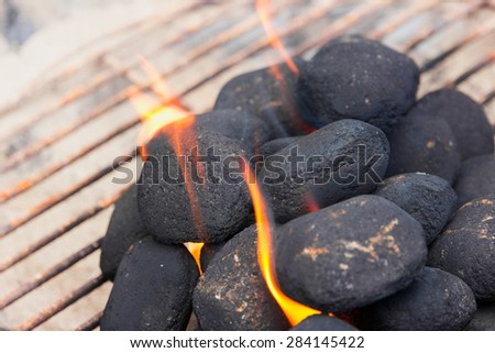 Charcoal briquettes on fire in a BBQ