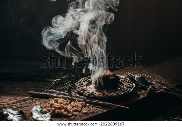 Charcoal burning with incense, incense resin,\
rosemary, \
laurel, lavender on a rustic wooden table,smudging,\
energetic cleansing\
.Sahumar\

