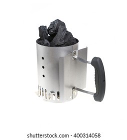 Charcoal chimney starter loaded with natural lump charcoal for BBQ grills.