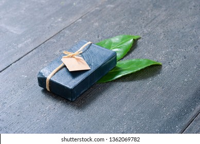 Charcoal Soap And Herbal Leaves On Black Wooden