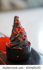 Charcoal Soft Serve Ice Cream Topped Red Chocolate, Served In Black Cup, Traditional Japanese Dessert, Healthy Concept.