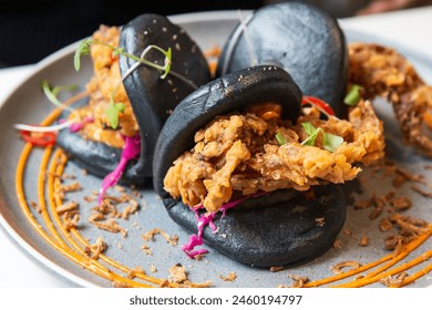 Charcoal-Black Bao Buns with Crispy Soft Shell Crab, Vibrant Veggies, and Savory Sauces on a Slate Plate - Powered by Shutterstock