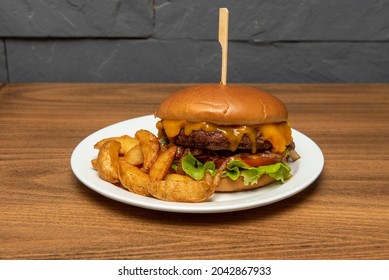 Charcoal-grilled Beef Burger With Dripping Melted Cheddar Cheese, Caramelized Onion, Tomato And Mustard With Wedge Fries