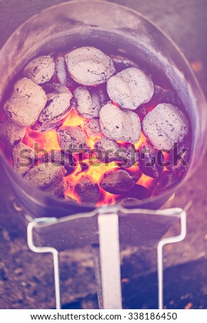 Charcoals in metal container prepared for barbecue grill.
