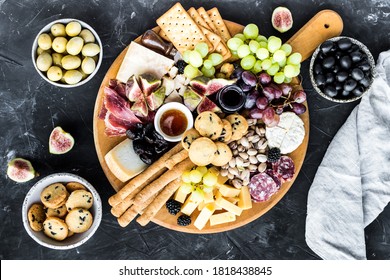 Charcuterie board. Cheese platter: Parmesan, maasdam, camembert, cheddar, gouda with prosciutto, salami, fruits and nuts. Assortment of tasty appetizers or antipasti. Top view. Copy space.