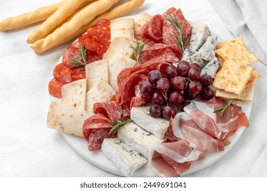 Charcuterie board. Food antipasto prosciutto ham, salami, olives and grissini bread sticks. cheese on a board parmesan, pecorino, gorgonzola.  - Powered by Shutterstock