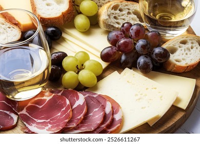 a charcuterie board with sliced cured meat, assorted cheeses, grapes, olives, and sliced bread - Powered by Shutterstock