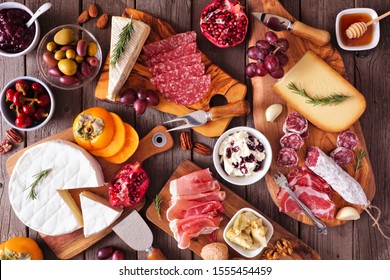 Charcuterie boards of assorted cheeses, meats and appetizers. Above view table scene on a rustic wood background. - Powered by Shutterstock